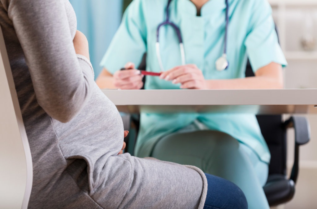 Mulher grávida em consulta médica para diagnóstico de trombofilia