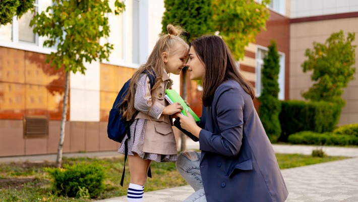 Mãe a apoiar a filha no primeiro dia de escola